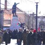 Everyone, in somber dress gathering by the monument that honours the 1848 Uprising